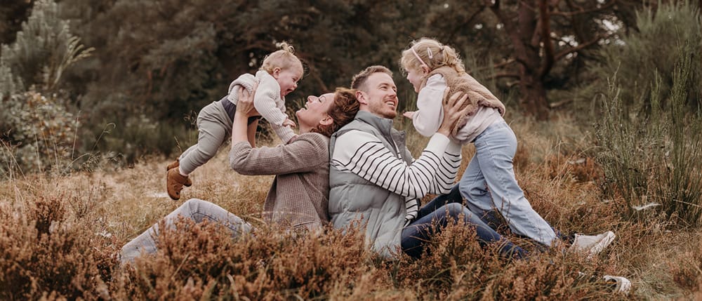 Spontane foto van gezin van vier op een gezinsfotoshoot op buitenlocatie